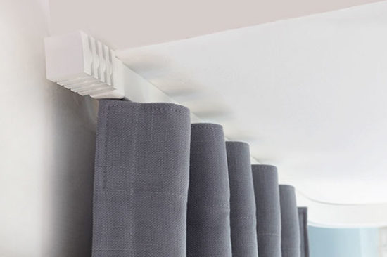Curved curtain track system with grey curtains